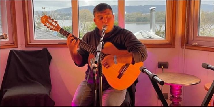 Guitarrista tocando frente al ventanal